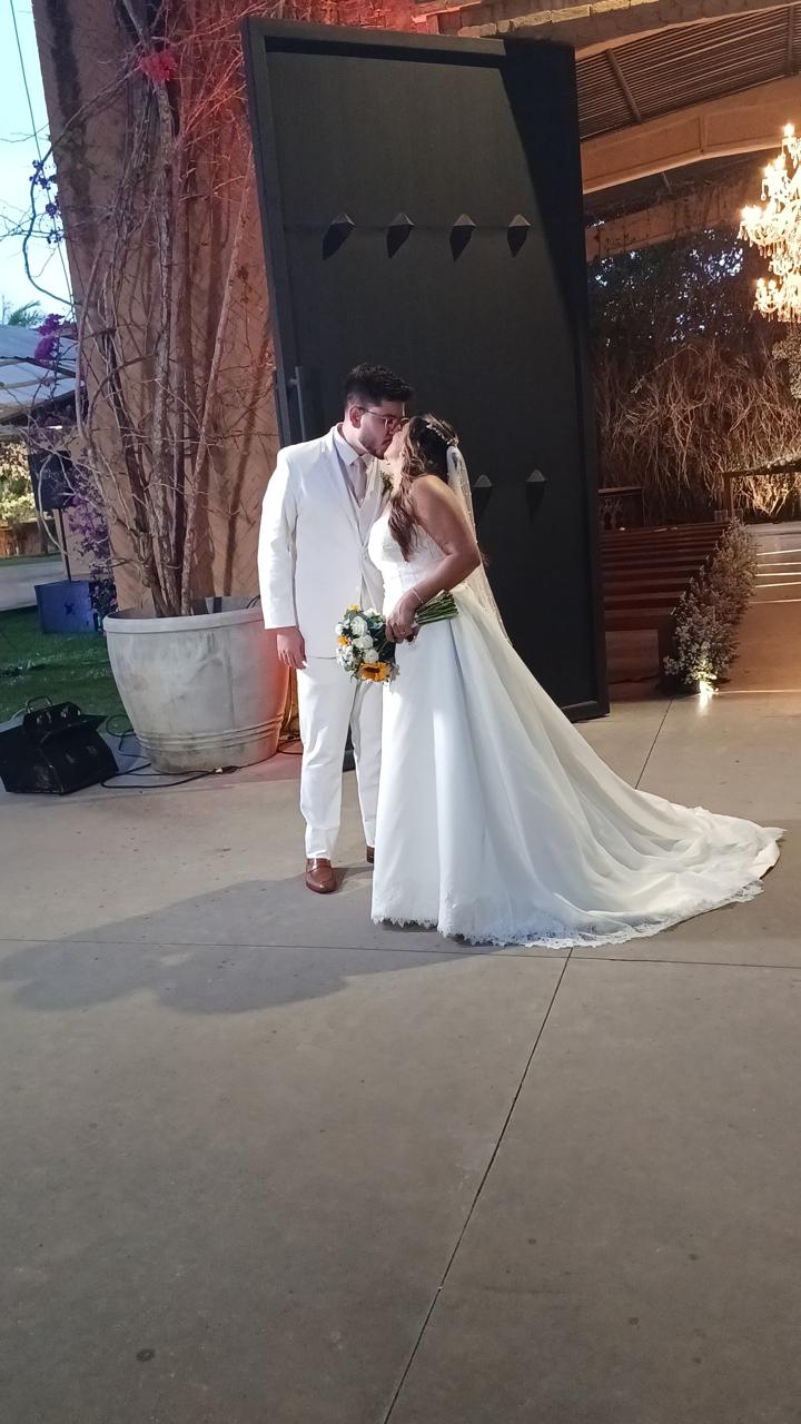 Noivos saindo da capela ao fim do casamento e trocando um beijo