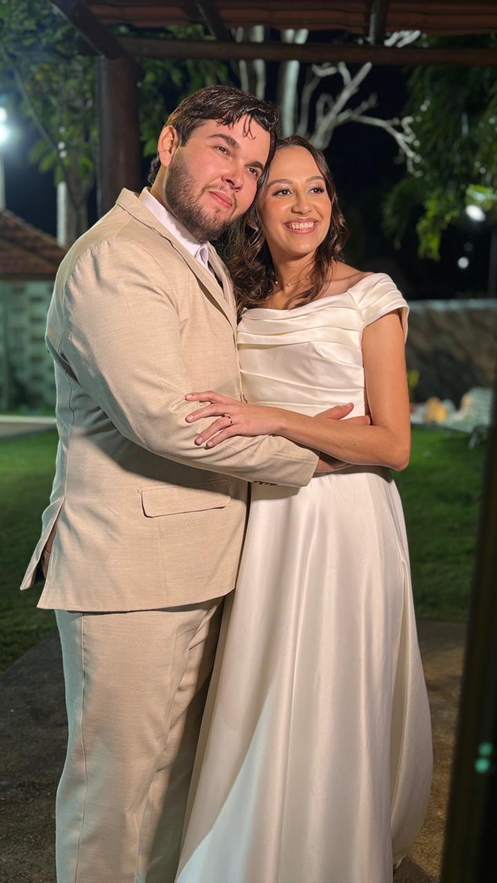 Aniversariante com um vestido branco, sorrindo para uma foto na cabine de fotos